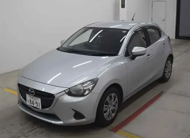 A Silver Hatchback Car, Available For Sale, Is Parked Indoors On A Concrete Floor With Japanese License Plates. The Car, Viewed From The Front Left Side, Showcases Its Sleek Design And Shiny Surface. Perfect For Driving Through The Vibrant Streets Of Kenya.